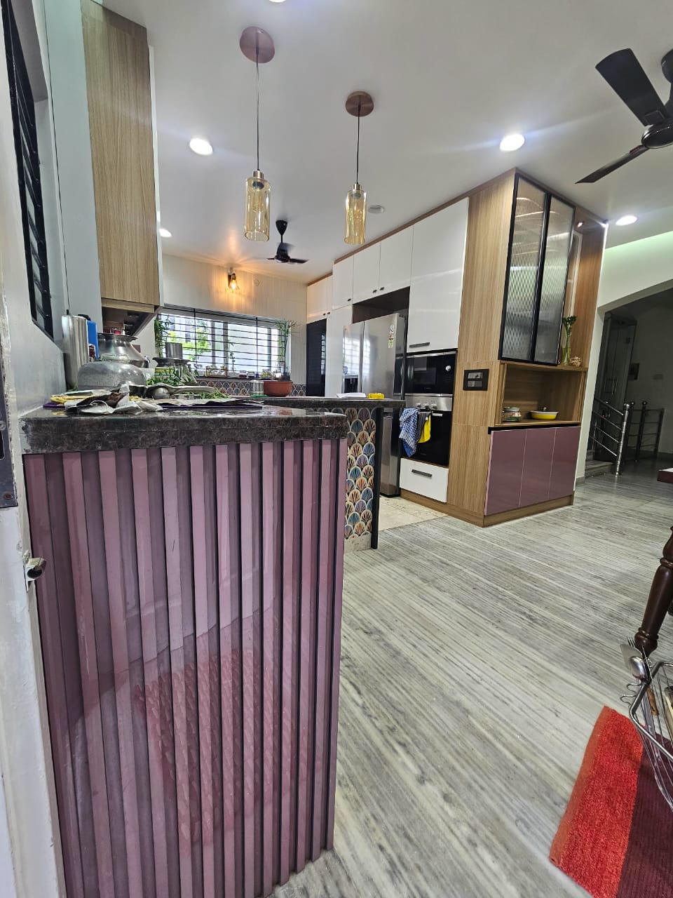 Open plan kitchen with fluted counter and tall appliance tower